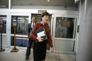Sen. Susan Collins, R-Maine, followed by Sen. Brian Schatz, D-Hawaii, join other senators in a rush to the Senate floor on Capitol Hill in Washington, Thursday, Dec. 11, 2014, for a procedural vote to advance the $585 billion defense bill. With a  midnight Thursday deadline to keep the government running,  a $1.1 trillion government-wide spending bill is teetering as many lawmakers find more in the measure to dislike than like. (AP Photo/J. Scott Applewhite)