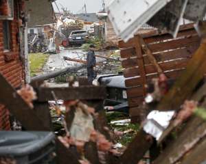 A man walks down the street past destroyed homes after a tornado tore through the  eastern part of New Orleans, Tuesday, Feb. 7, 2017.   The National Weather Service says at least three confirmed tornadoes have touched down, including one inside the New Orleans city limits. Buildings have been damaged and power lines are down. (AP Photo/Gerald Herbert)